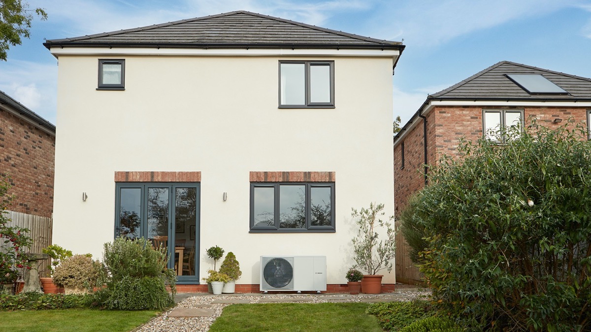 Detached house with air source heat pump installed in the garden